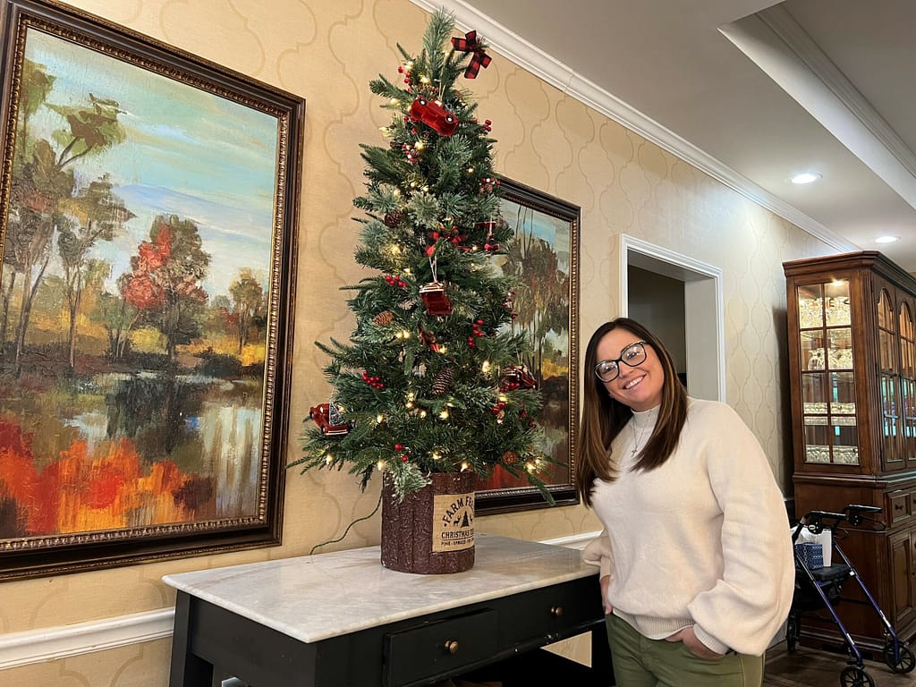 photo of Sam from AccentCare delivering a Christmas tree to Morning Pointe of Greenbriar Cove 