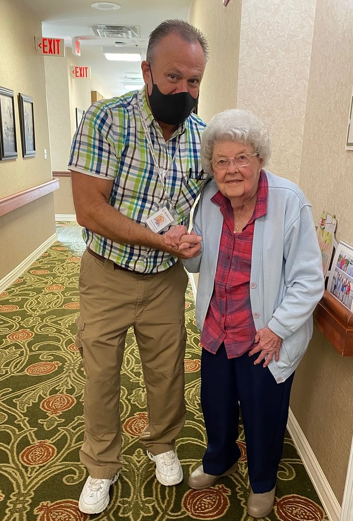 photo of therapist helping resident with balance in hallway