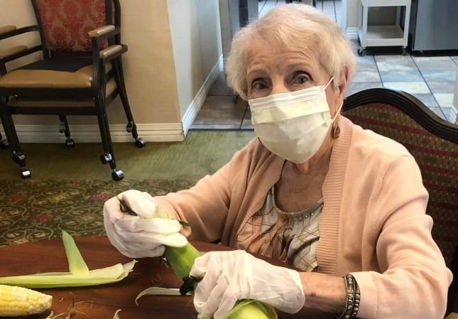 Senior lady husking corn