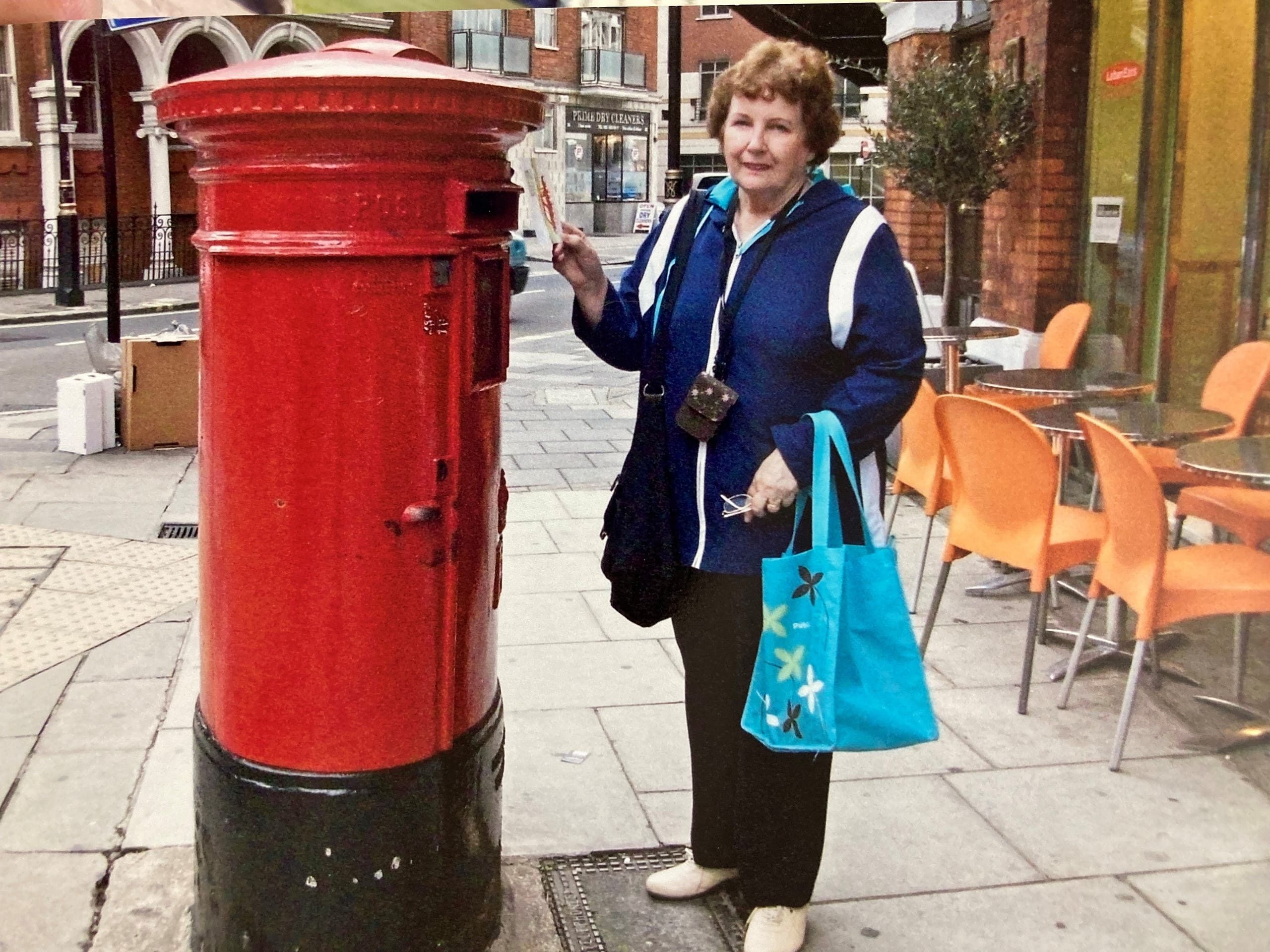 photo of Joan mailing a letter at a British mailbox