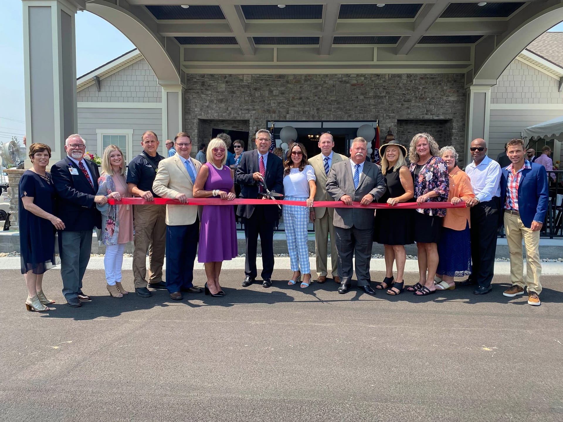 Group of employees cutting the ribbon to celebrate re-opening