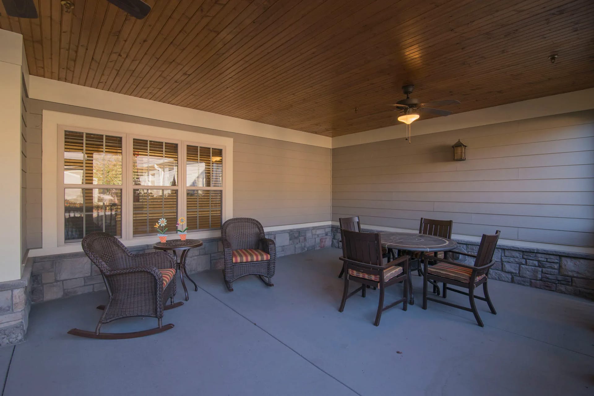 Brentwood campus porch with table and rocking chairs