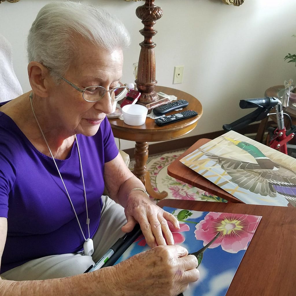 Senior woman at Morning Pointe Senior Living painting a picture of flowers