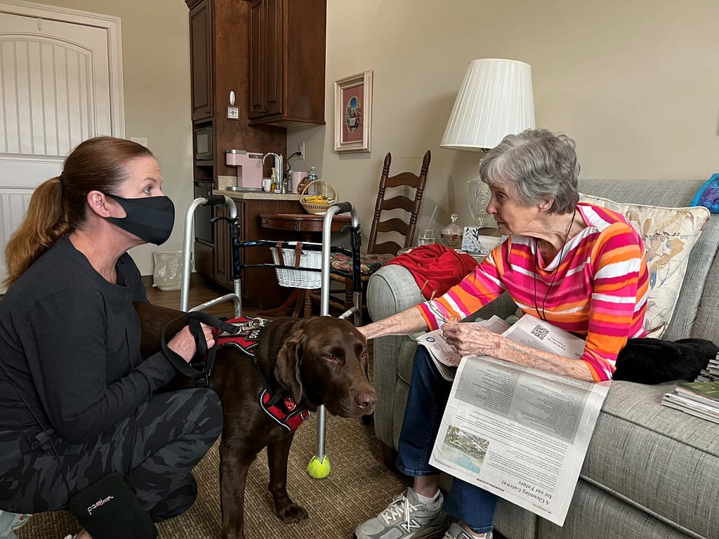 Photo of volunteer Jill with her dog, Aero, visiting resident Frances at Morning Pointe of East Hamilton in Chattanooga, TN