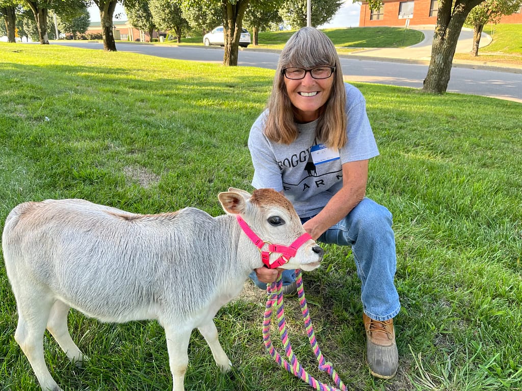 photo of Charla Young of Foggy Bottom Farm with a 4-month-old miniature zebu named Boo