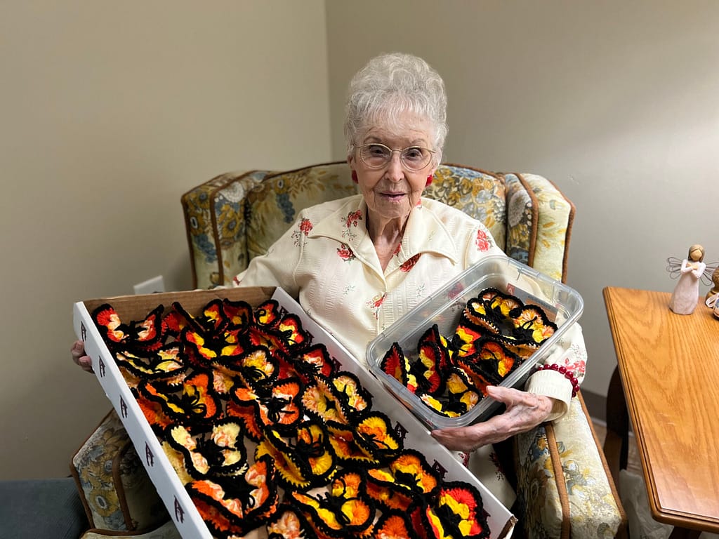 photo of Virginia Lee with some of her crocheted butterflies