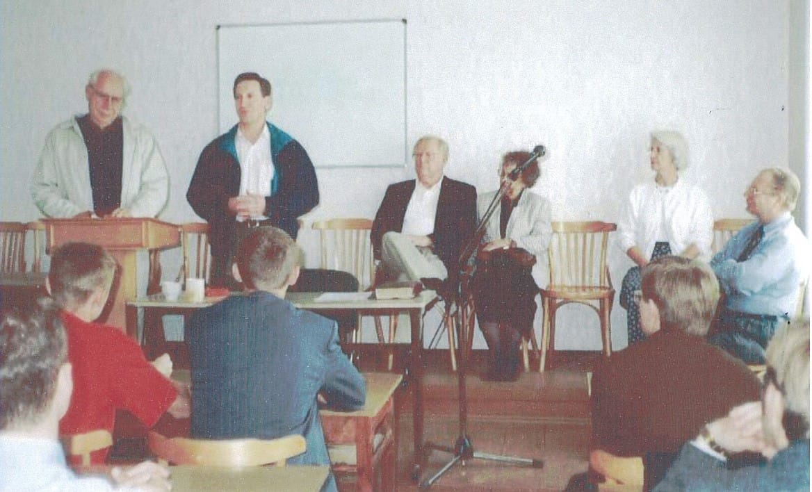photo of Ted on the far left speaking to the first group of students at one of the overseas seminaries – Ann is second from right