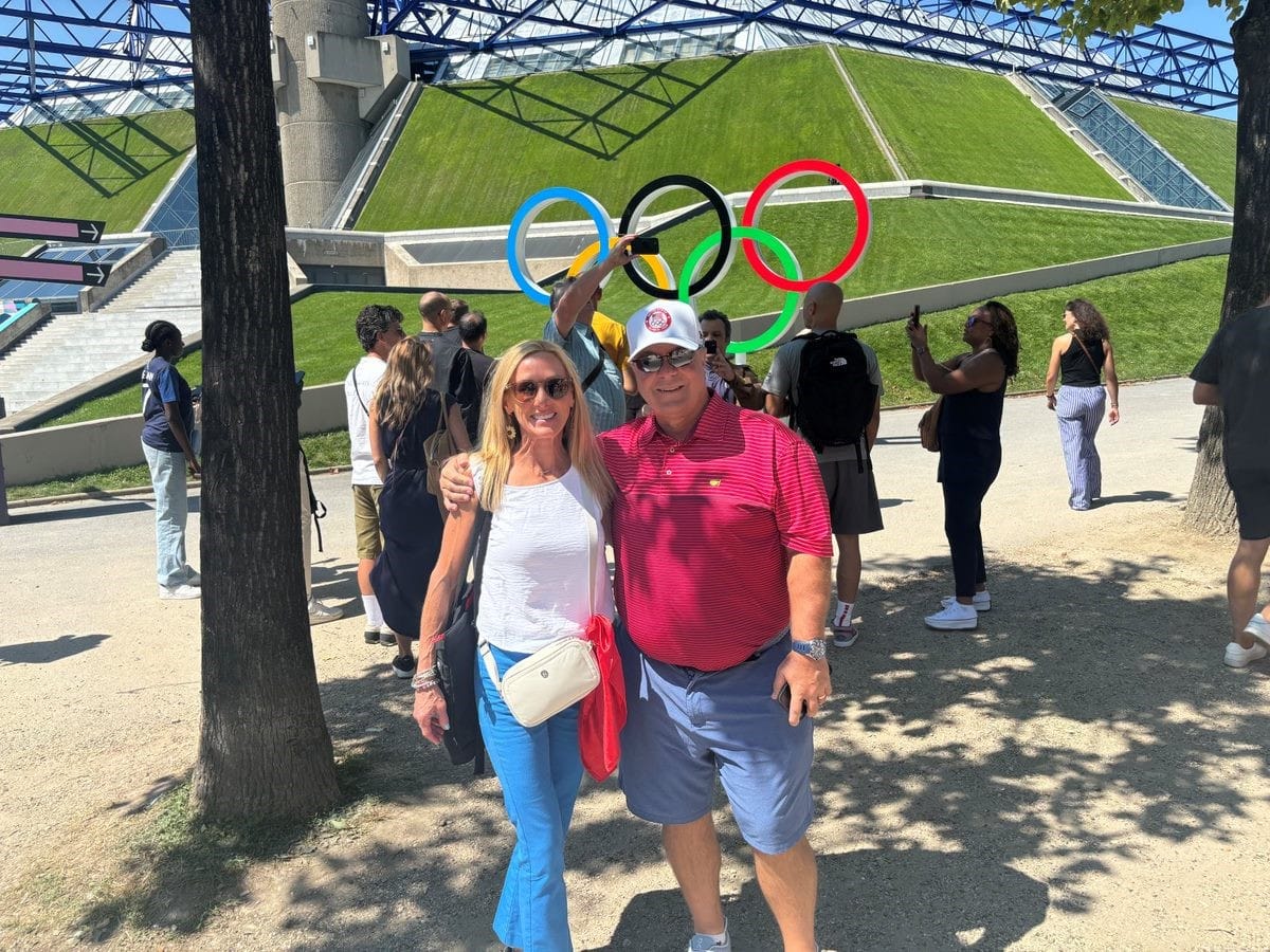 photo of Nicole with her husband in front of the stadium