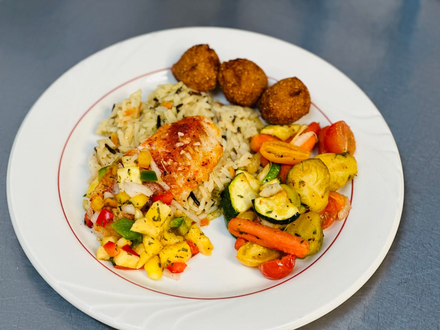 photo of fish and hush puppies and fresh vegetables