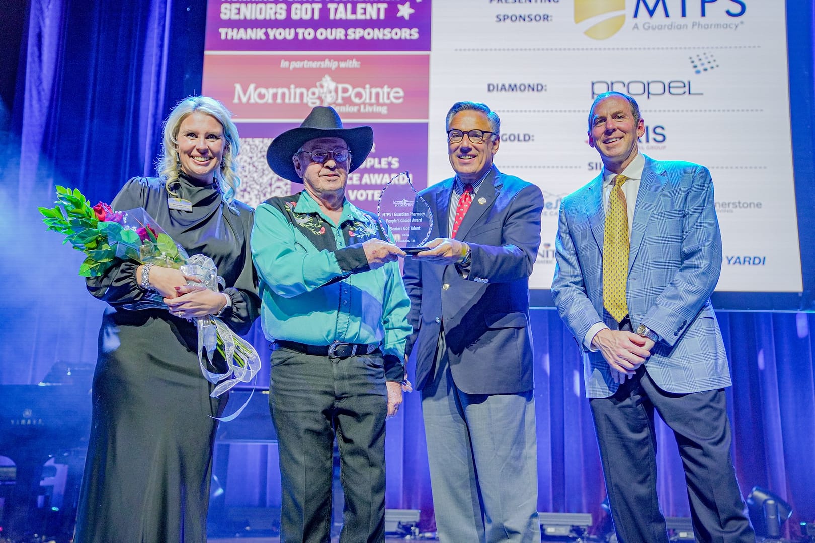 photo of the People's Choice Award, left to right: Miranda Perez, Morning Pointe Foundation executive director; People's Choice winner Bill Schneider; Greg A. Vital, Morning Pointe Senior Living president; and Franklin Farrow, Morning Pointe Senior Living CEO