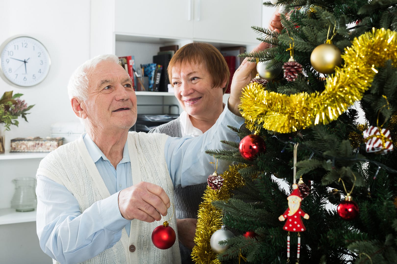 stock photo of older gentleman decorating Christmas tree