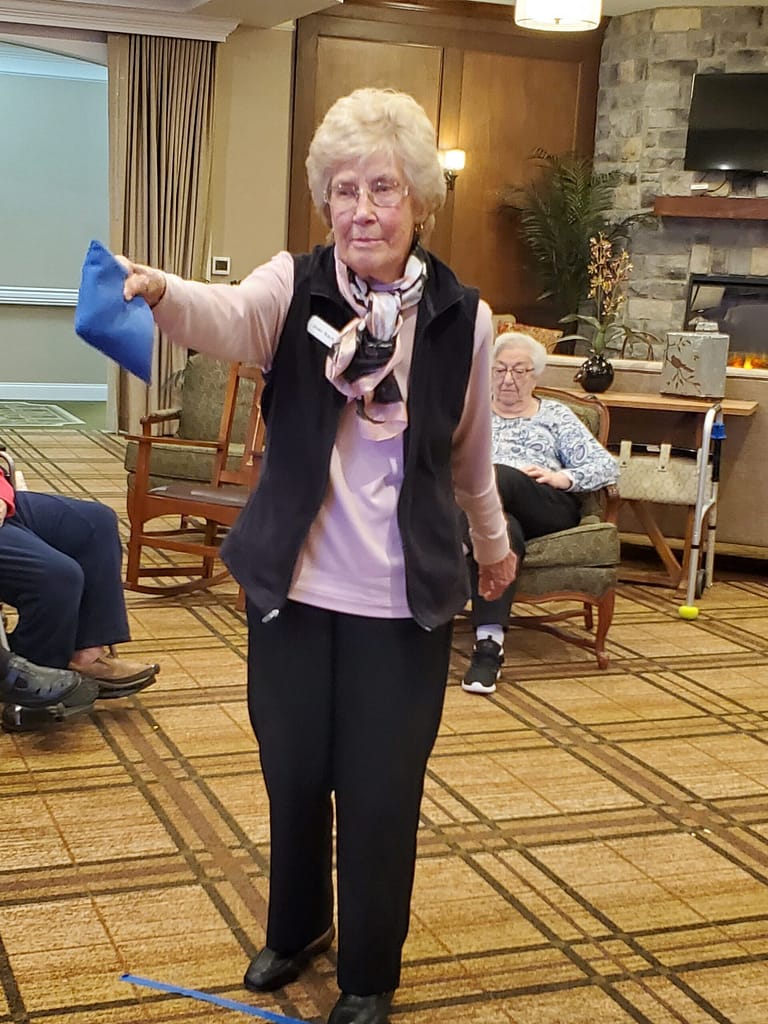 photo of Joan Bachman, resident at Morning Pointe of Knoxville, practicing cornhole