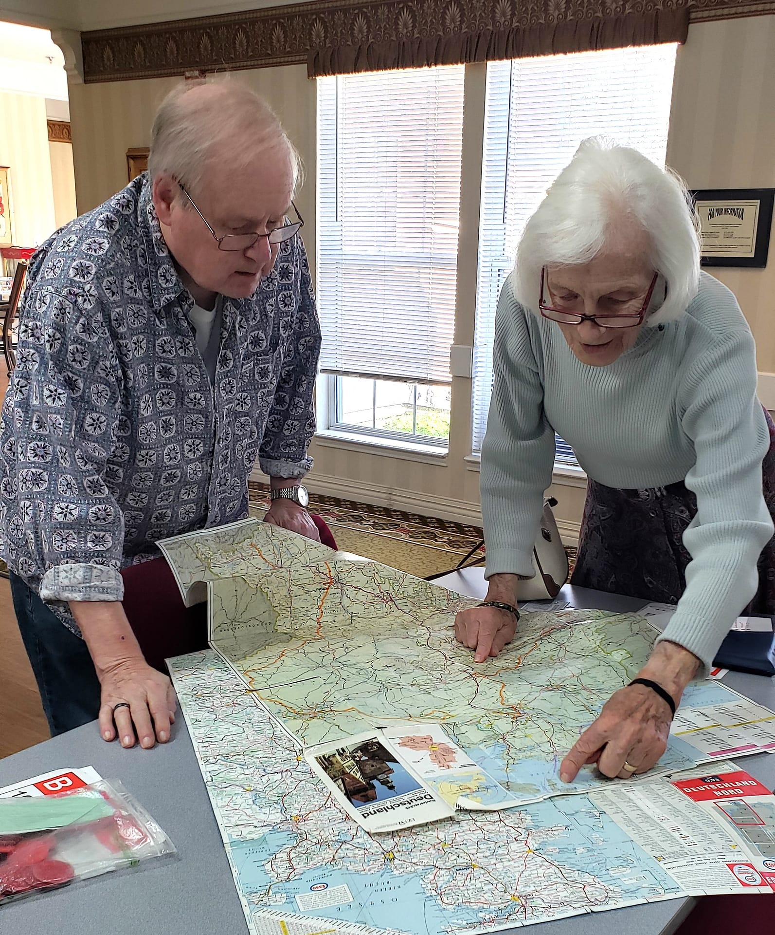 photo of Christel showing a fellow resident a map of where she grew up in Germany