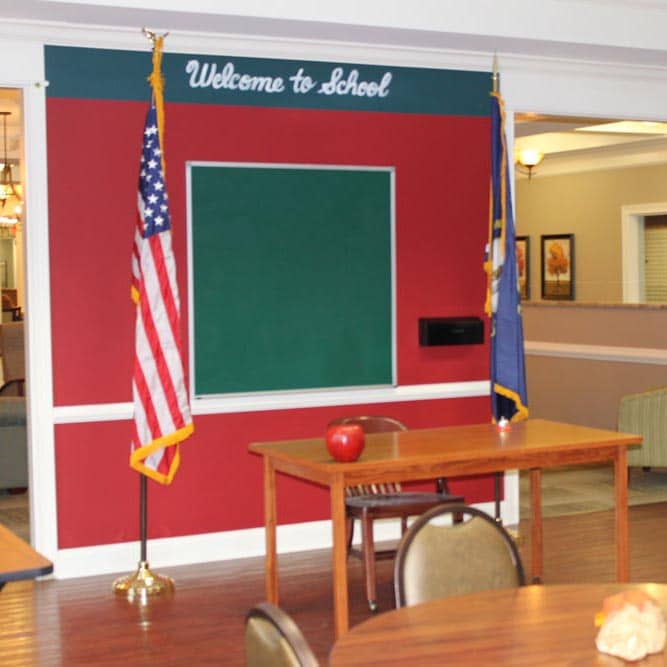 Classroom set up with a teacher's desk and sign reading "welcome to school"