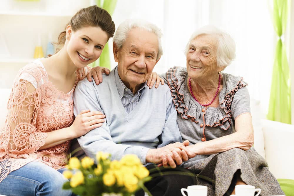 Daughter visiting senior parents at senior living alzheimer's respite care community