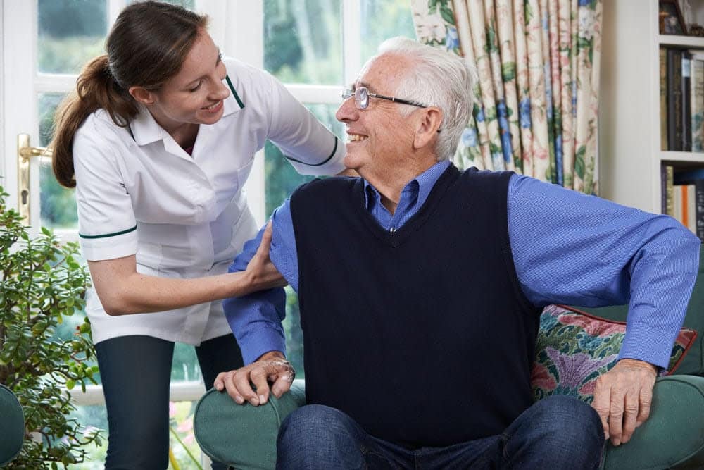 Senior living caregiver helping elderly resident at a senior living community