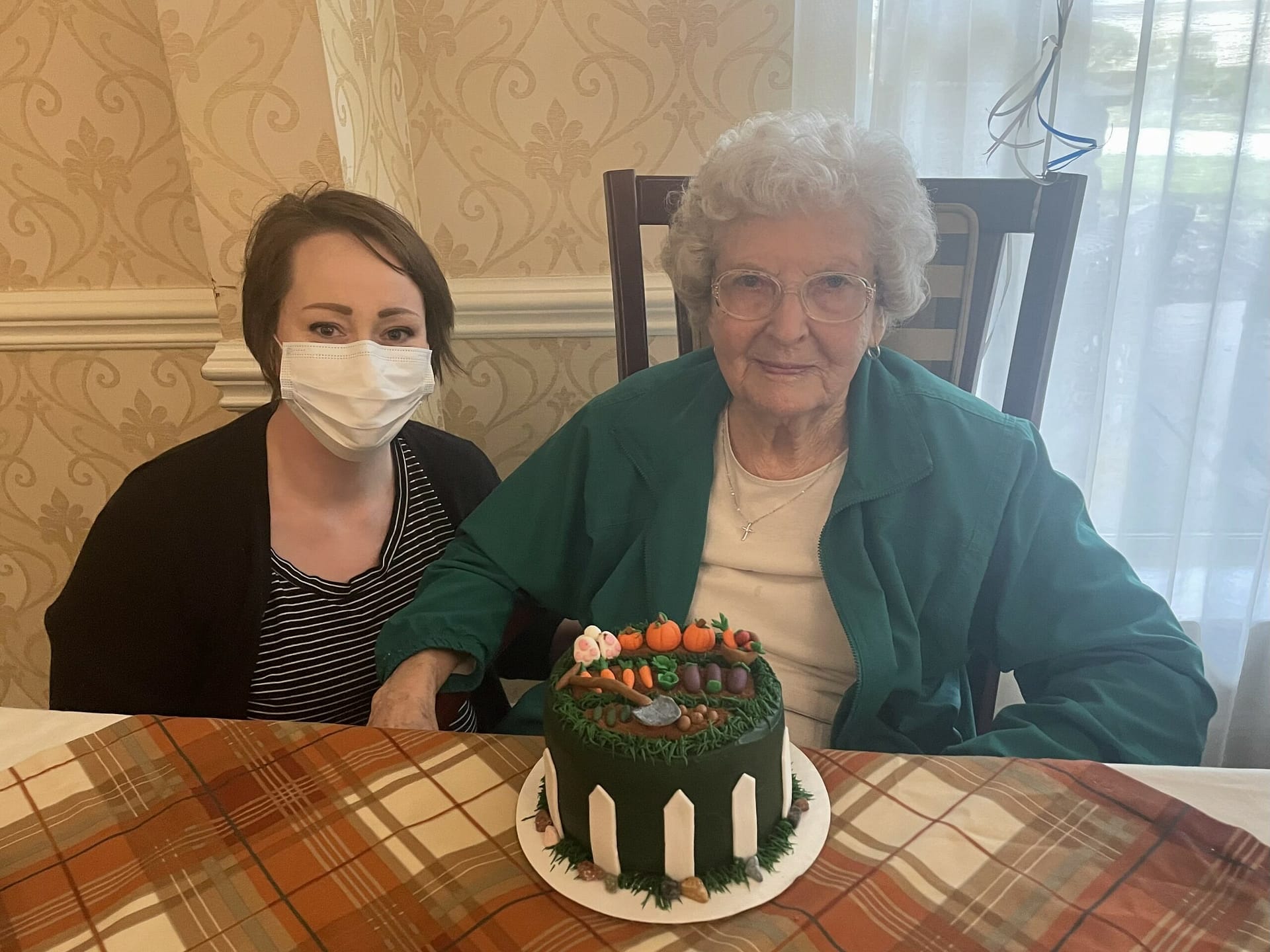 photo of Alicia Allmon with resident Sue Mitchell and her garden cake